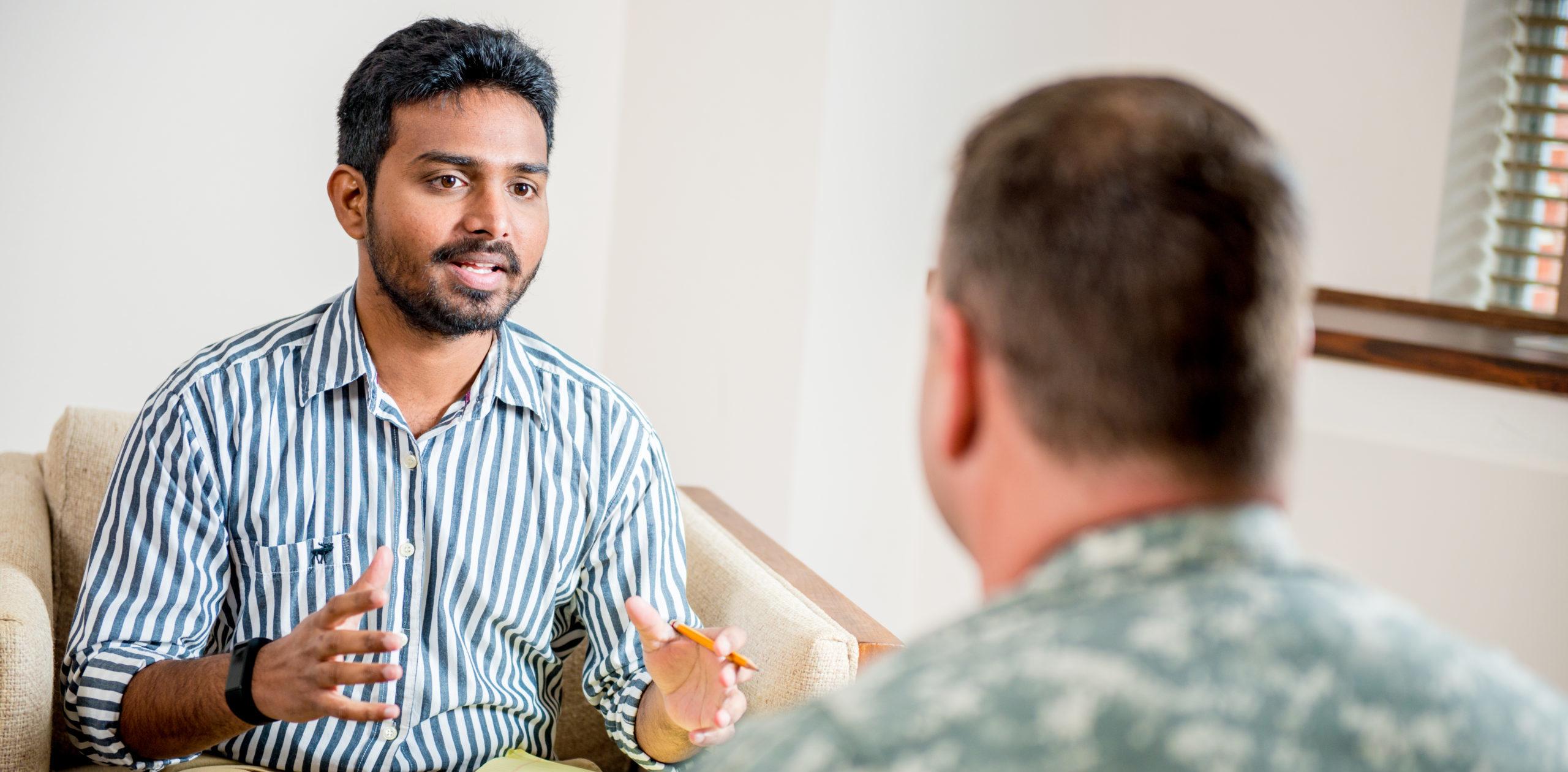 Social worker talking to man in the military.